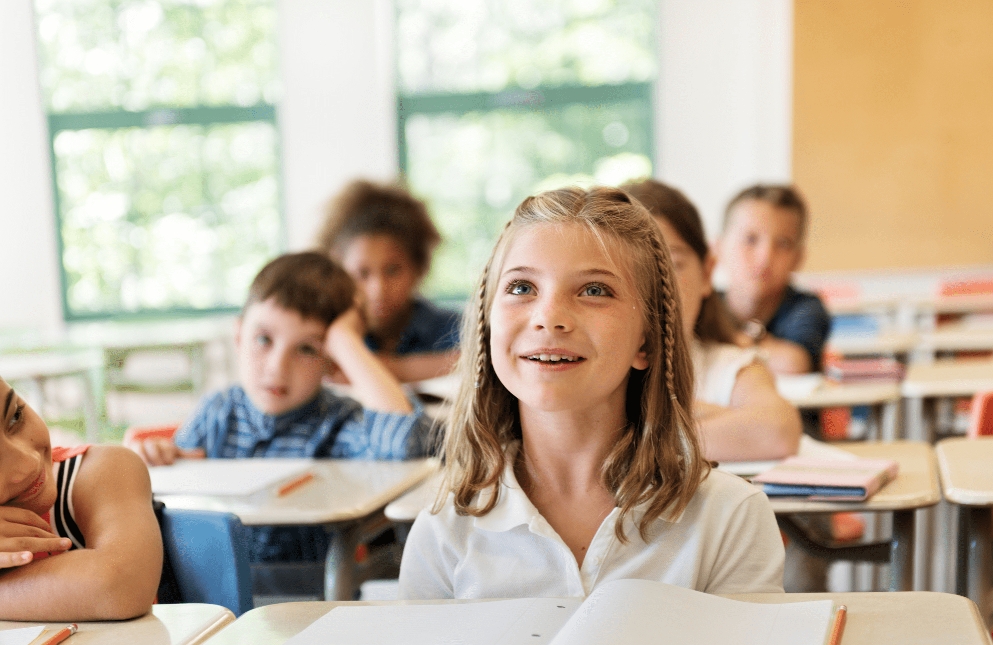 Little girl looking forward in a classroom full of kids