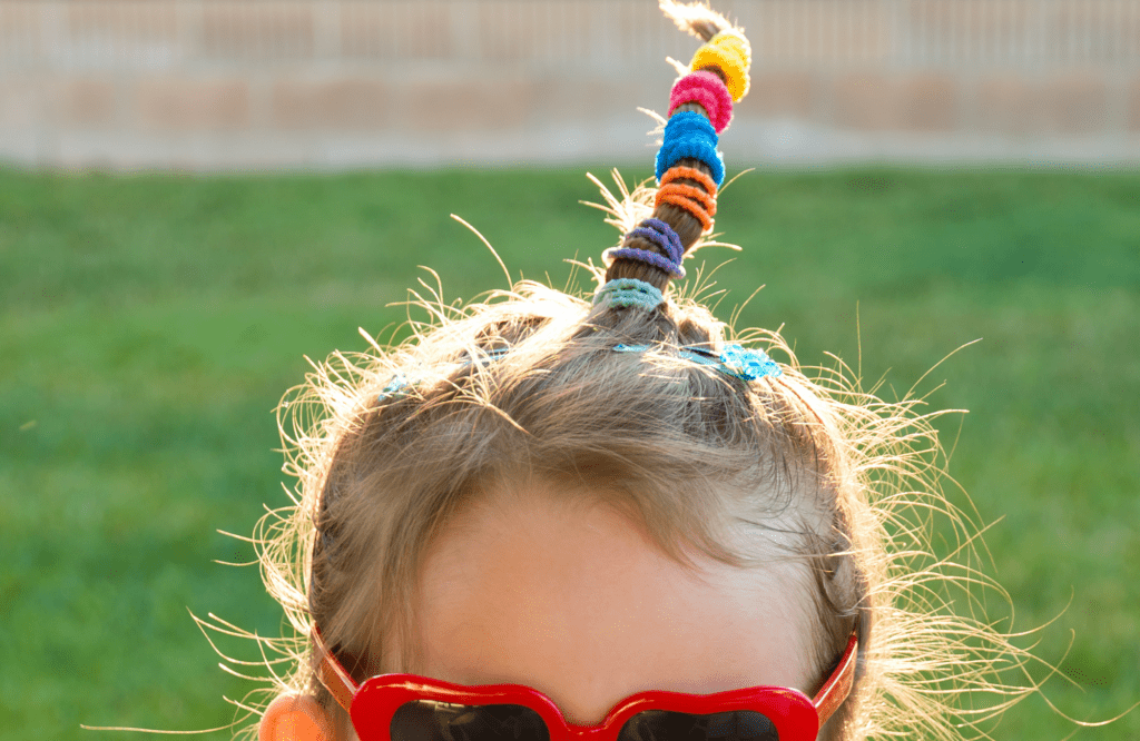 little girl with crazy hair. hair pulled up on top of her head with several hair bands holding it straight up