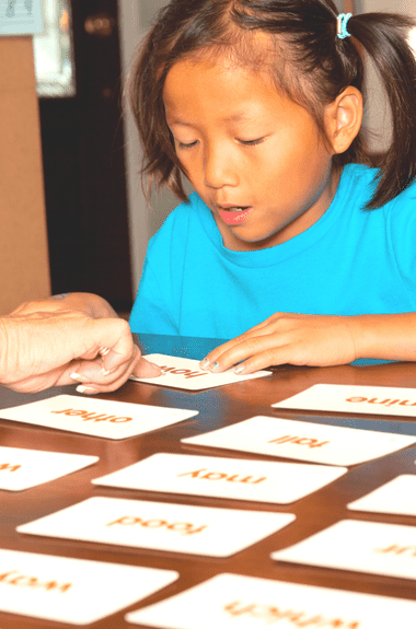 girl practicing site words at a table